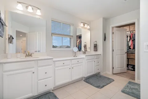 a spacious bathroom with double sink and a mirror