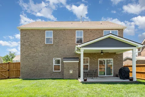a view of a brick house with a large window and a yard