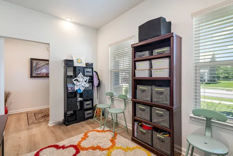 a bedroom with a bed a dresser and book shelf