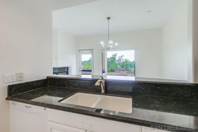 a kitchen with stainless steel appliances granite countertop a sink refrigerator and cabinets