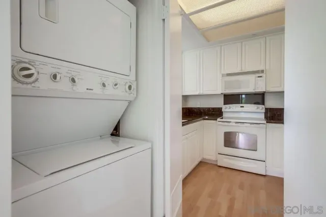 a kitchen with white cabinets and white appliances