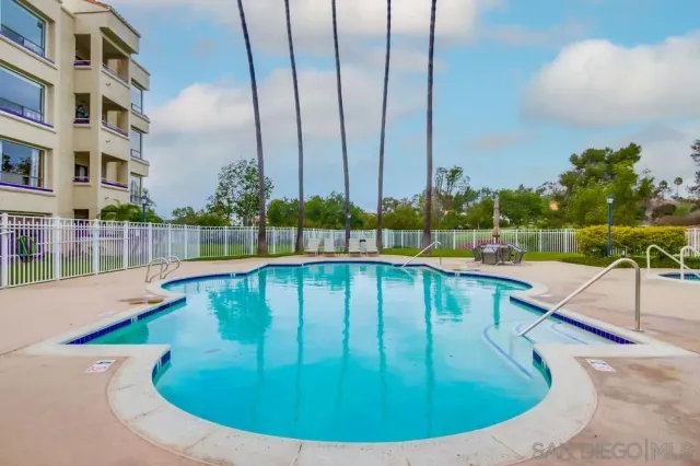 a view of a swimming pool with a deck and a garden