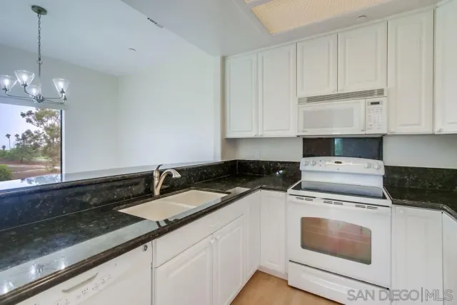 a kitchen with a sink and chandelier