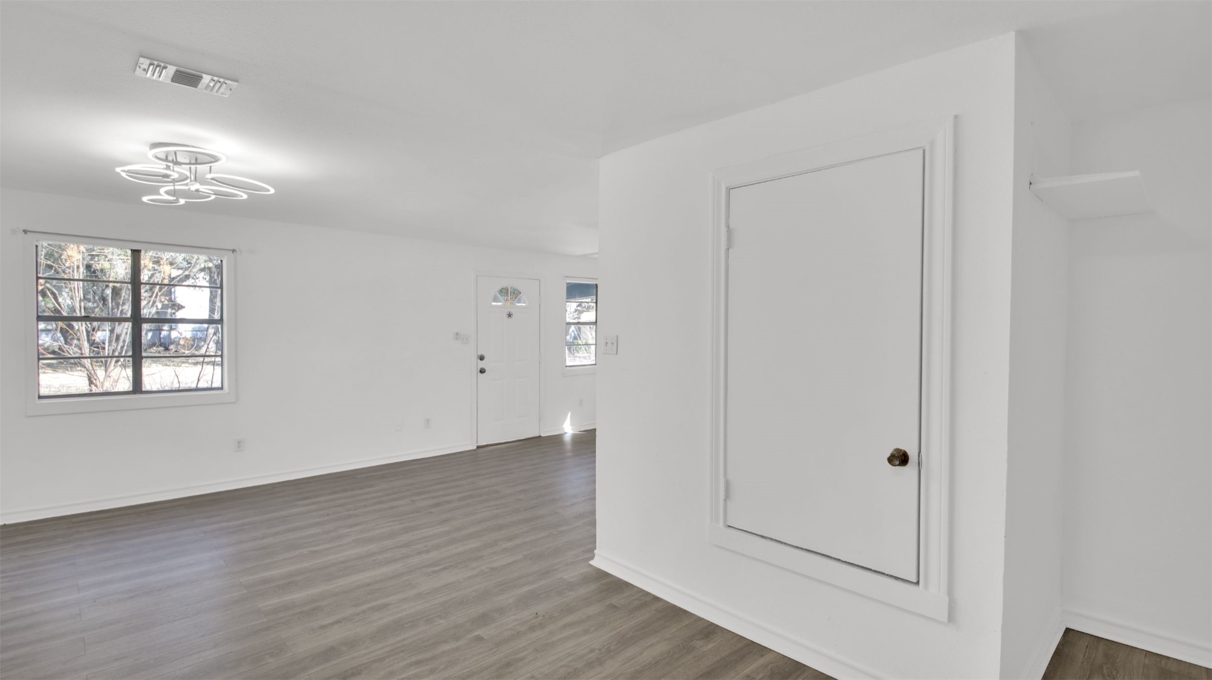 908 Tank Street Lockhart, TX 78644 - Photo 18 of 22 an empty room with wooden floor cabinet and windows