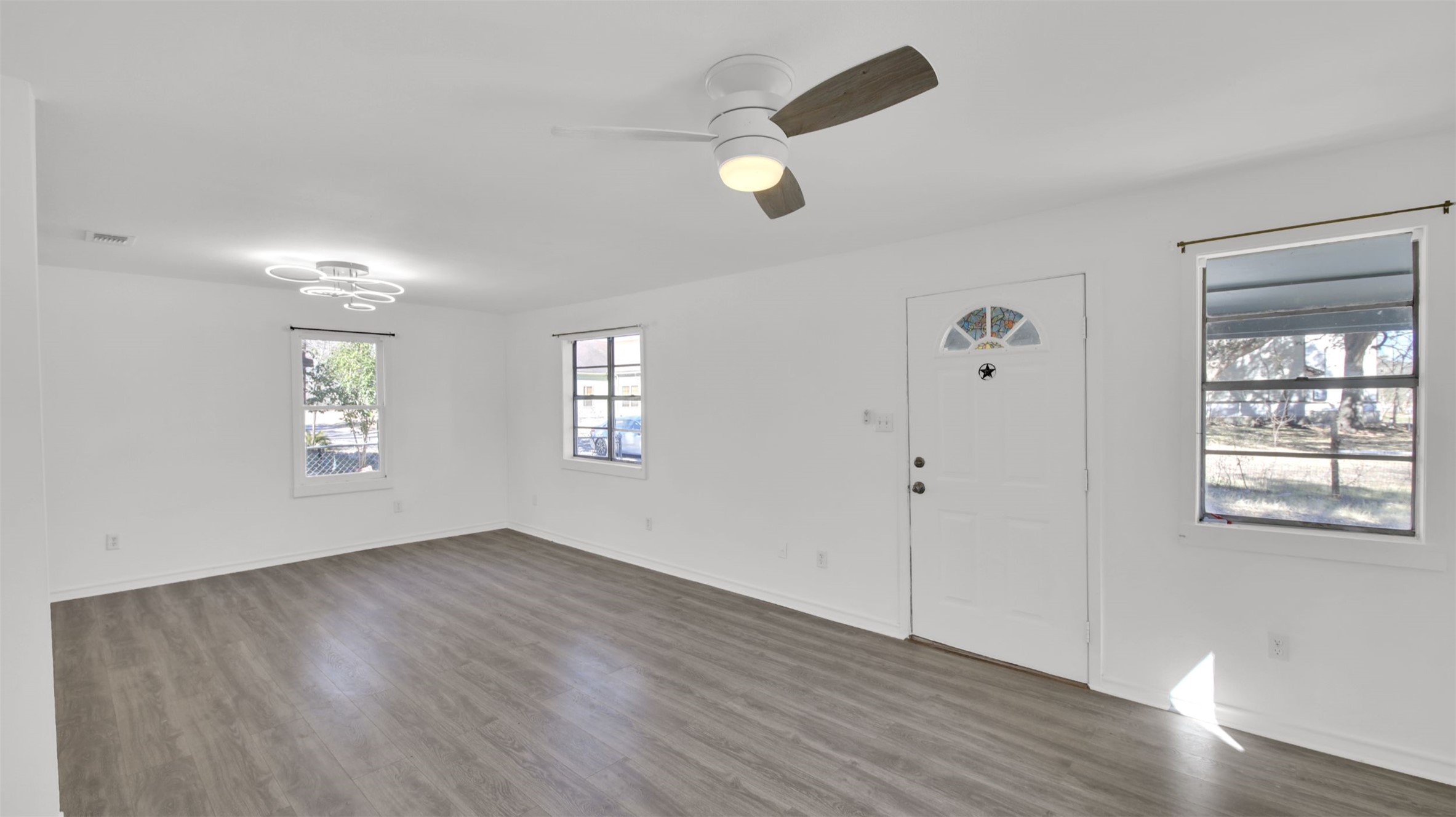 908 Tank Street Lockhart, TX 78644 - Photo 3 of 22 a view of an empty room with a window and wooden floor