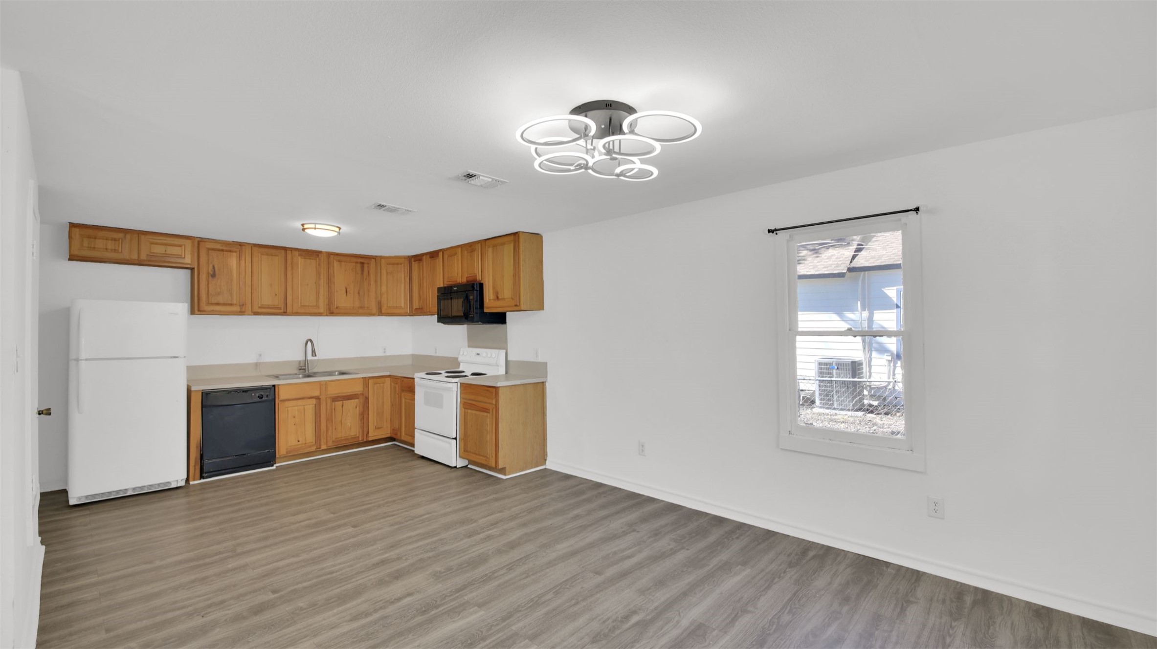 908 Tank Street Lockhart, TX 78644 - Photo 6 of 22 a view of a kitchen with a sink dishwasher and wooden floor