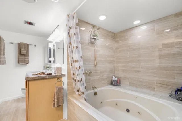 a bathroom with a tub sink and mirror