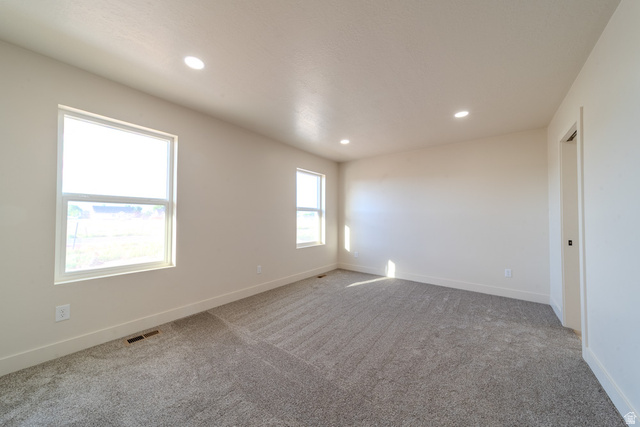 130 Pole Line Road, Unit 2 Roosevelt, UT 84066 - Photo 21 of 33 Spacious room featuring neutral carpeting, recessed ceiling lighting, and two expansive windows providing natural illumination
