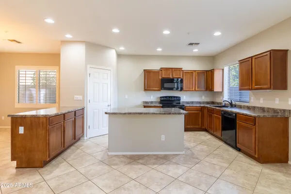 a large kitchen with stainless steel appliances granite countertop a stove sink and cabinets