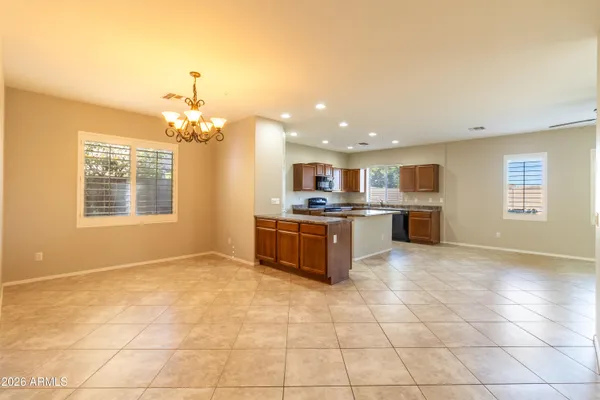a large kitchen with kitchen island a chandelier stainless steel appliances cabinets and a counter top space