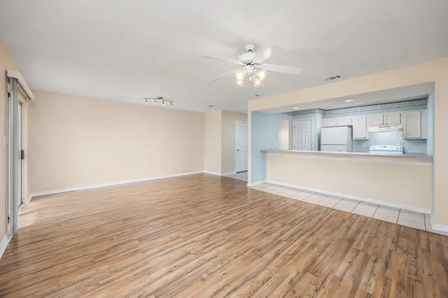 a view of a kitchen with wooden floor and a ceiling fan