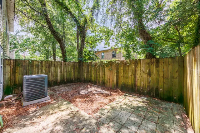 a view of a house with a backyard and wooden fence