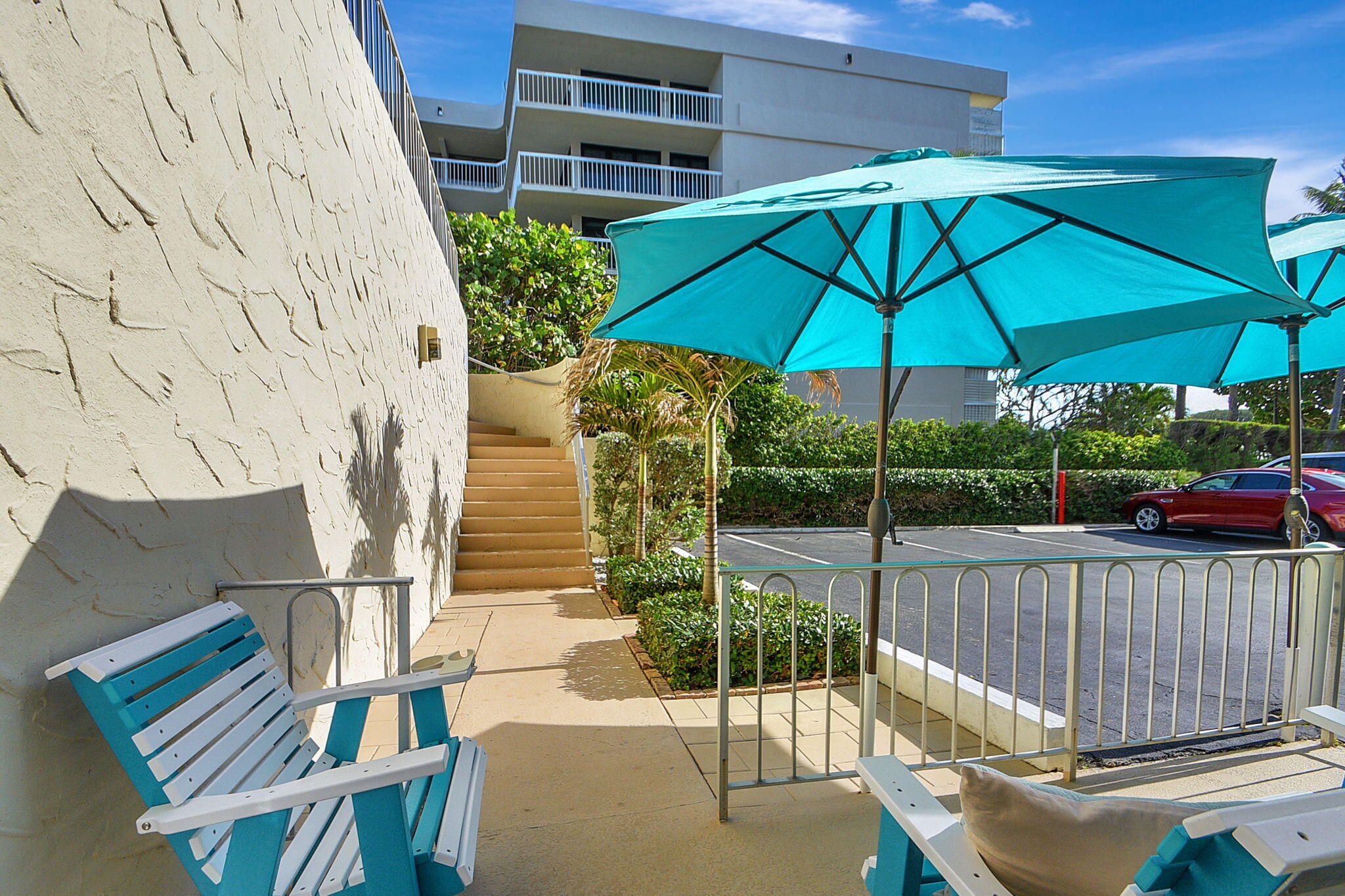 3230 South Ocean Boulevard, Unit C100 Palm Beach, FL 33480 - Photo 14 of 49 a view of balcony with wooden floor and umbrella
