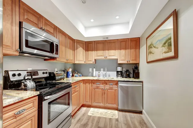 a kitchen with stainless steel appliances granite countertop a stove a microwave and a cabinets