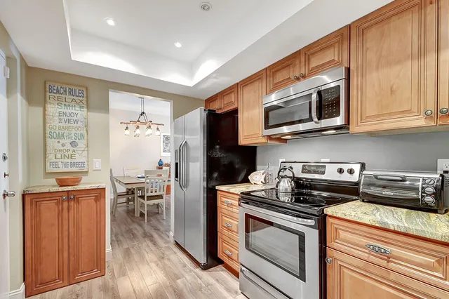 a view of a hallway with wooden floor and a living room