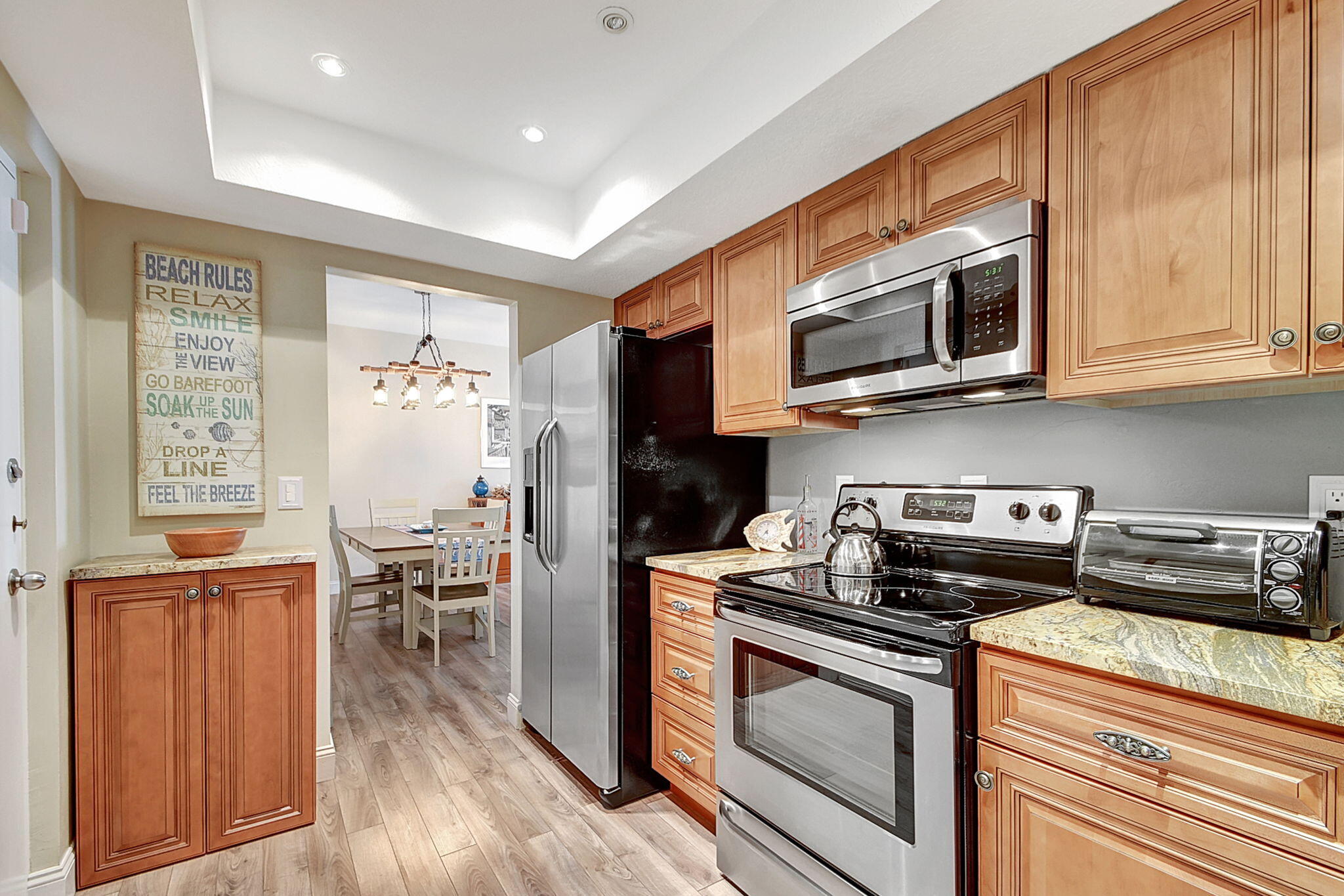 3230 South Ocean Boulevard, Unit C100 Palm Beach, FL 33480 - Photo 23 of 49 a kitchen with stainless steel appliances granite countertop a stove a microwave and a cabinets