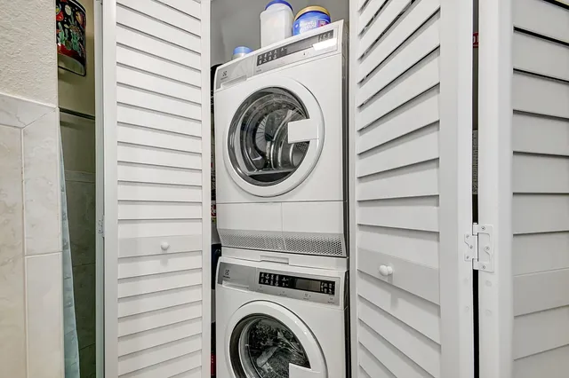 a bedroom with a bed a couch and a flat tv screen on dresser