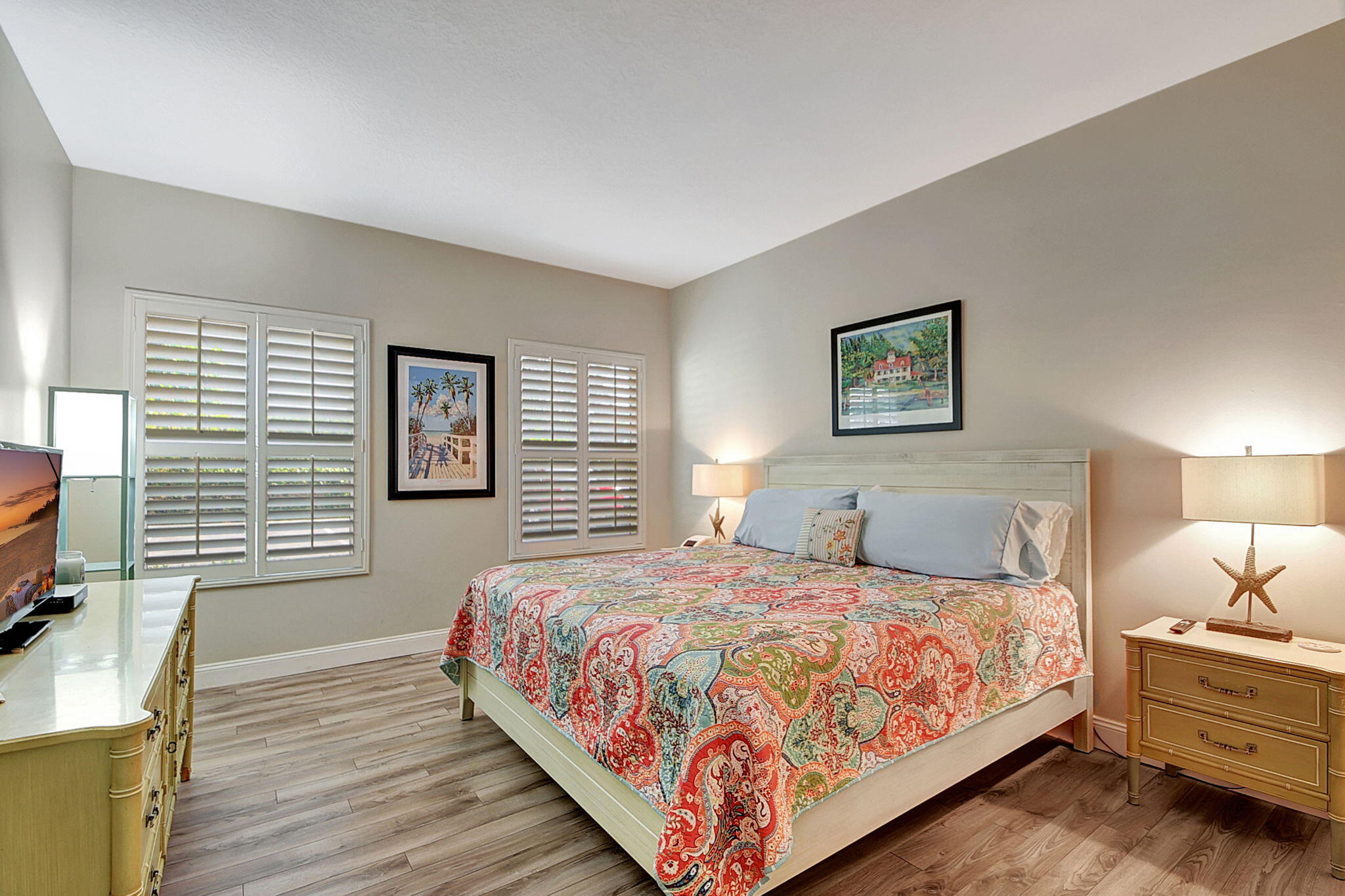 3230 South Ocean Boulevard, Unit C100 Palm Beach, FL 33480 - Photo 30 of 49 a bedroom with a bed a couch and a flat tv screen on dresser