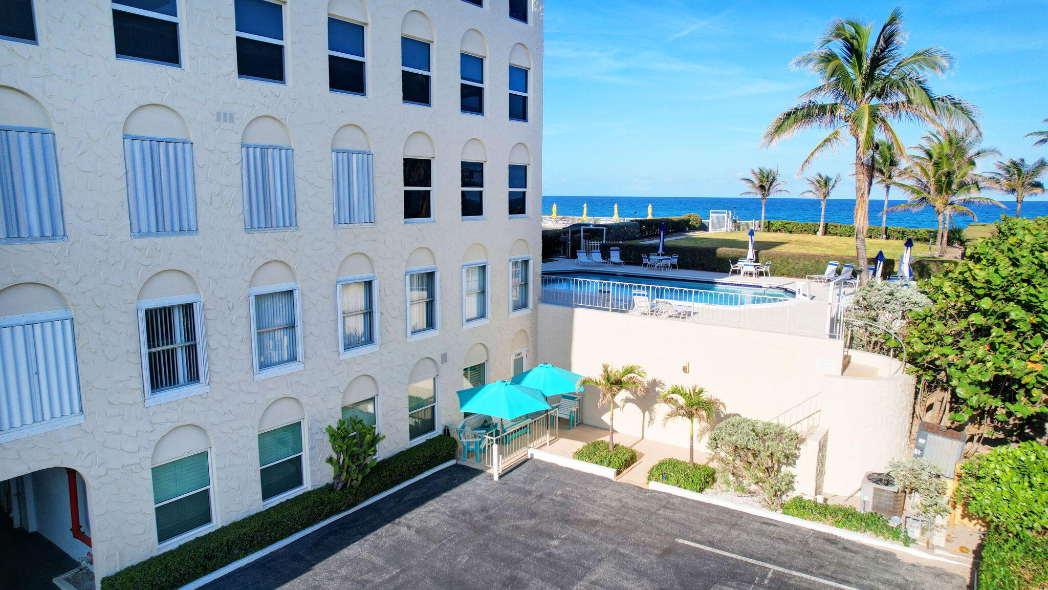 3230 South Ocean Boulevard, Unit C100 Palm Beach, FL 33480 - Photo 36 of 49 a front view of a multi story residential apartment building with a yard