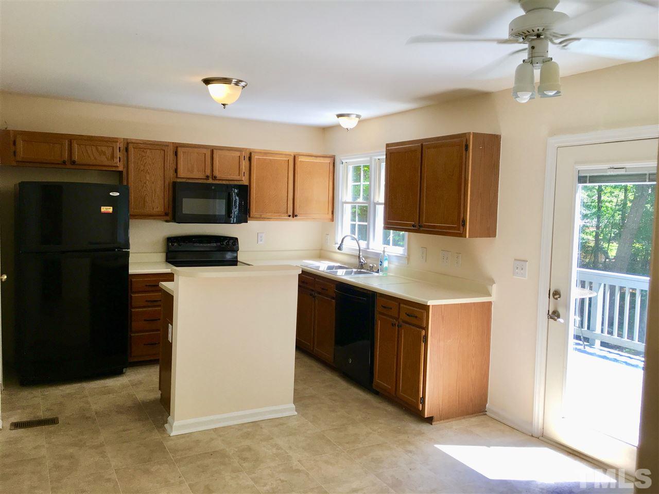 5217 Blakeley Lane Raleigh, NC 27613 - Photo 10 of 14 a kitchen with kitchen island granite countertop a refrigerator and a sink