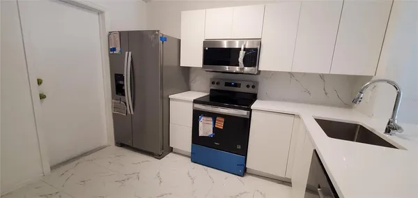 a kitchen with stainless steel appliances a refrigerator a stove a microwave and a refrigerator