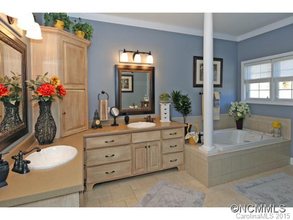 39 Hunters Trace Clyde, NC 28721 - Photo 12 of 18 a bathroom with a granite countertop tub a sink and a large mirror