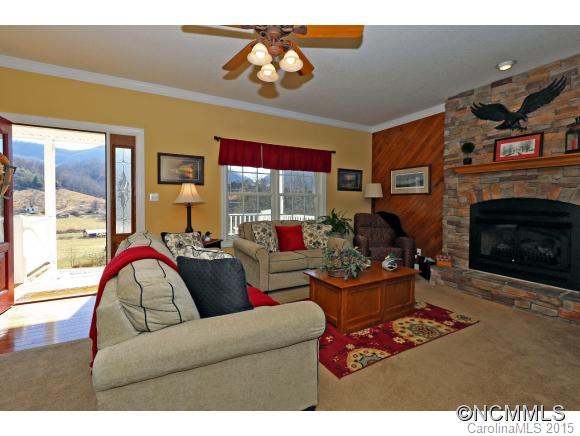 39 Hunters Trace Clyde, NC 28721 - Photo 5 of 18 a living room with furniture a fireplace and a large window