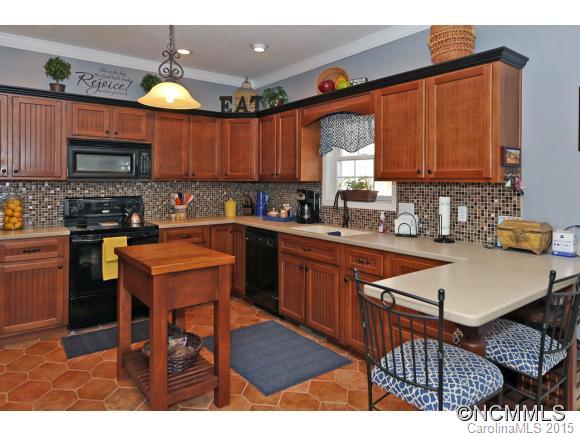 39 Hunters Trace Clyde, NC 28721 - Photo 6 of 18 a kitchen with stainless steel appliances kitchen island granite countertop a sink table and chairs