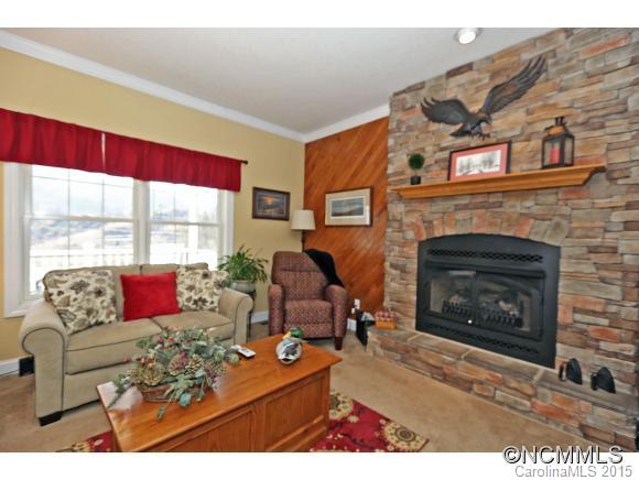 39 Hunters Trace Clyde, NC 28721 - Photo 7 of 18 a living room with furniture large window and a fireplace