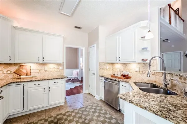 a kitchen with granite countertop a sink a stove and cabinets