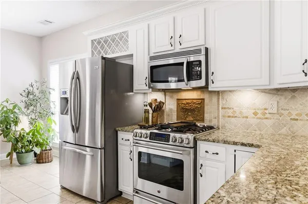 a kitchen with stainless steel appliances white cabinets and a stove top oven