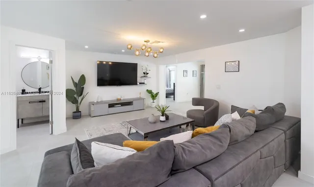 a living room with furniture flat screen tv and a lamp