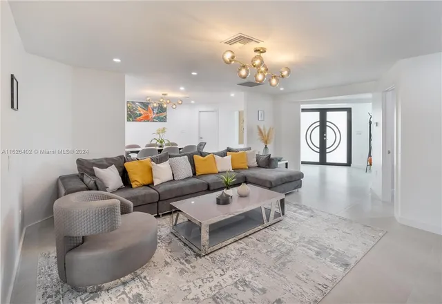 a living room with furniture a chandelier and a rug