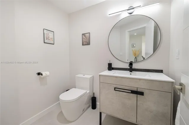 a bathroom with a toilet a sink and mirror