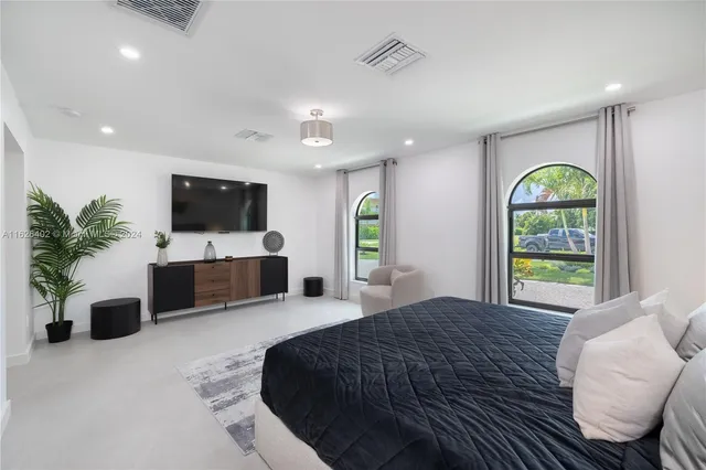 a bedroom with a balcony a bed and a flat screen television