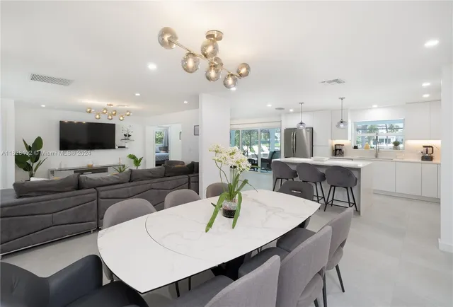 a living room with kitchen island furniture and a chandelier