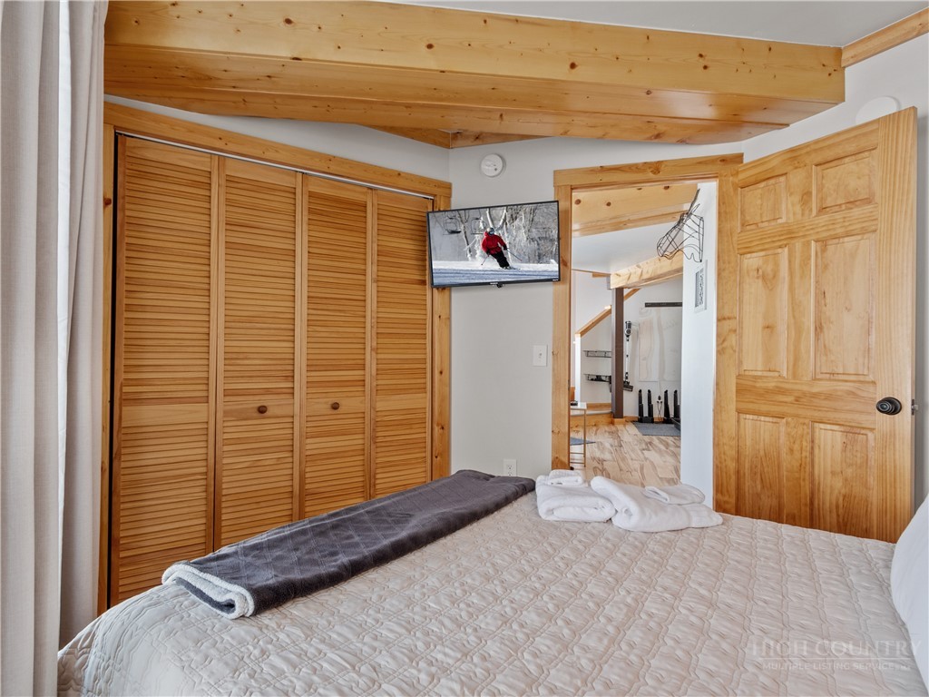 630 Briarcliff Road Sugar Mountain, NC 28604 - Photo 16 of 28 a bedroom with a bed and wooden floor
