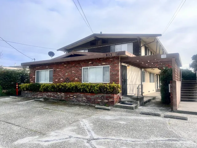 a front view of a house with lots of windows and plants