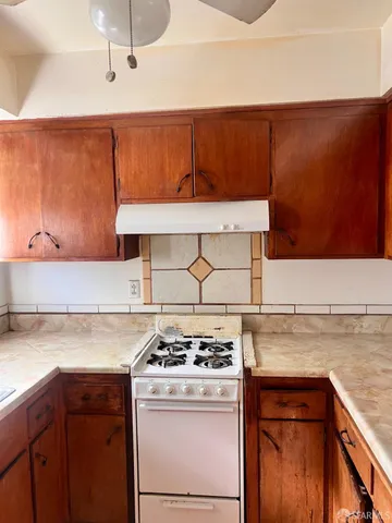 a kitchen with granite countertop cabinets and a stove top oven