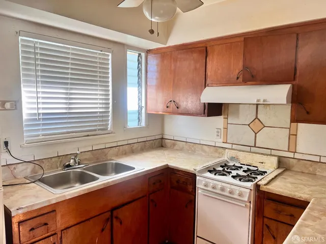a kitchen with stainless steel appliances a sink a stove and a refrigerator