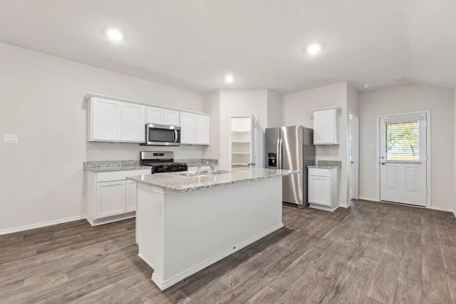 a kitchen with white cabinets and stainless steel appliances