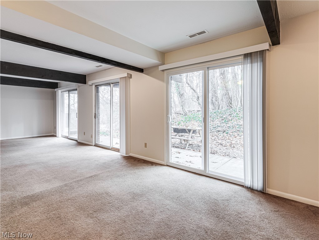 2550 Chamberlain Road, Unit A3 Akron, OH 44333 - Photo 10 of 21 Carpeted empty room with beamed ceiling