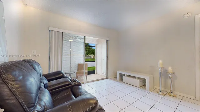 a living room with couches and kitchen view with wooden floor