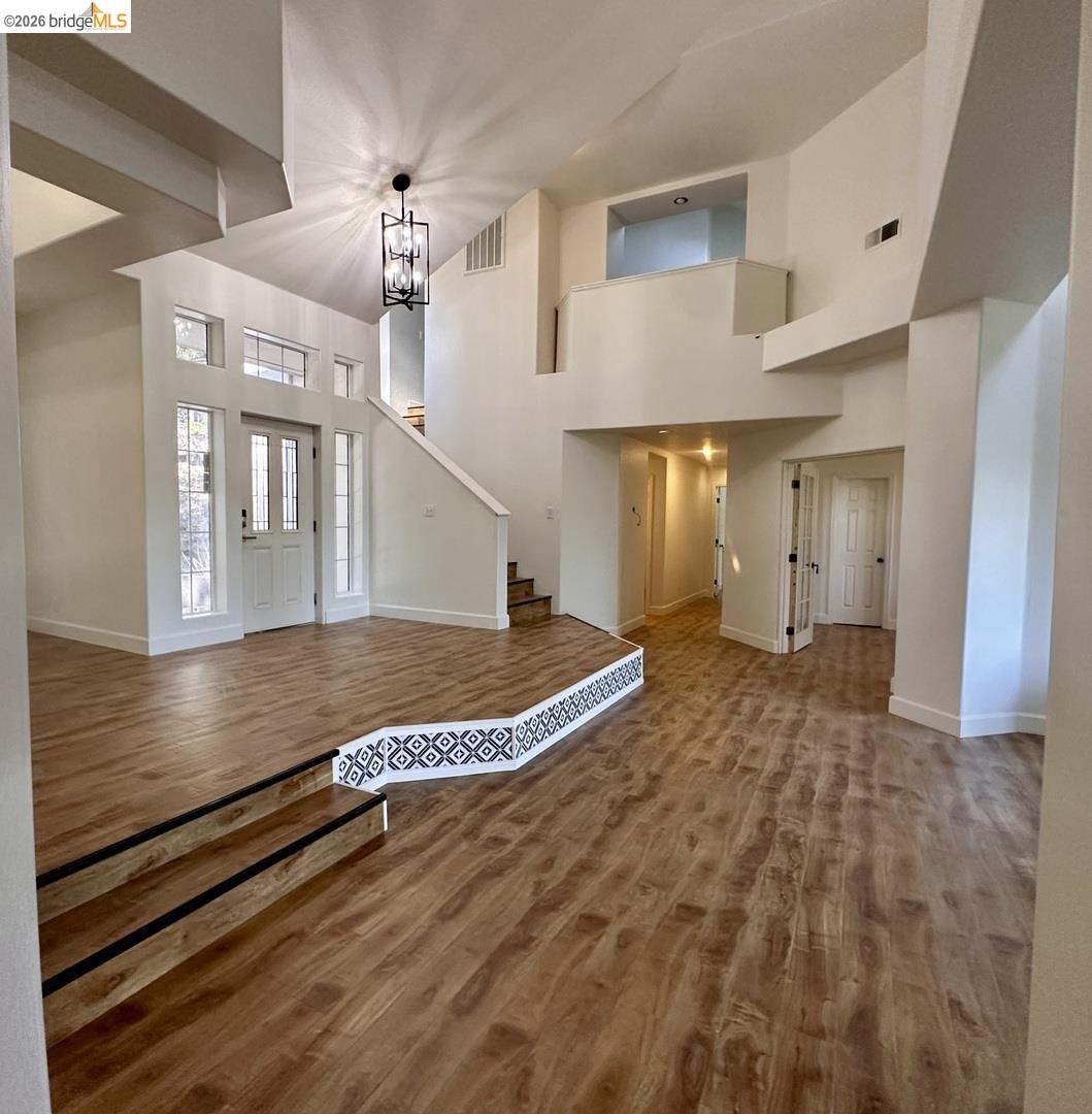 2080 Nelson Road Camino, CA 95709 - Photo 23 of 55 Two-story entryway with wood-finish flooring, a contemporary chandelier, a prominent staircase, and an upper-level overlook