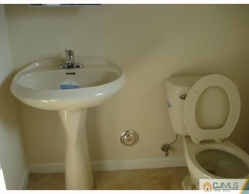 10 Edwin Street Carteret, NJ 07008 - Photo 3 of 10 a bathroom with a sink a toilet and a mirror