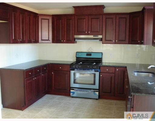 10 Edwin Street Carteret, NJ 07008 - Photo 4 of 10 a kitchen with granite countertop wooden cabinets and a wooden floor