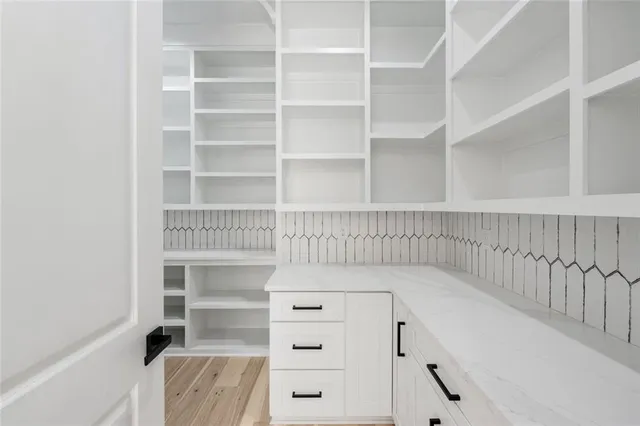 a view of an empty room with wooden floor and windows