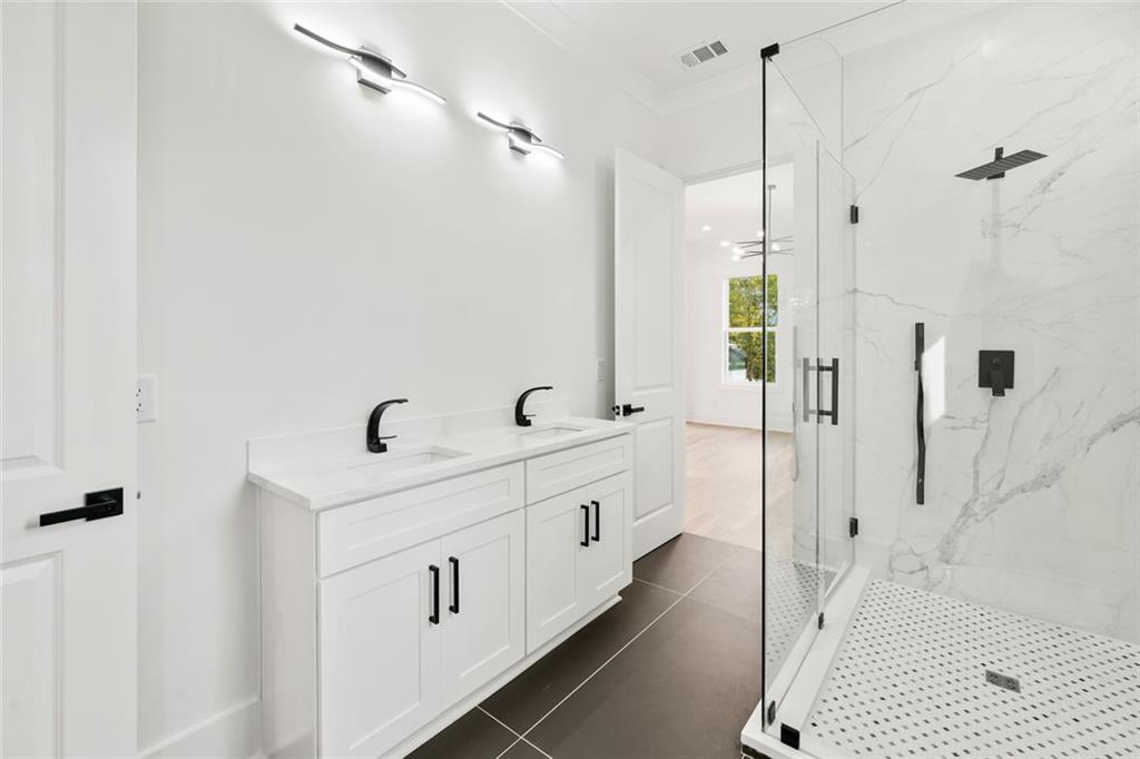 876 Bramlett Shoals Road Lawrenceville, GA 30045 - Photo 47 of 64 a bathroom with a double vanity sink a mirror and shower