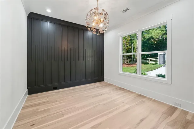 a view of an empty room with wooden floor and staircase