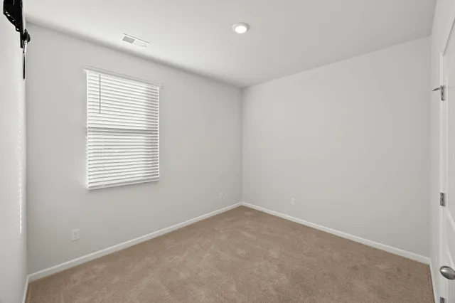 an empty room with an entryway and fan